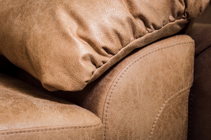 Close-up the Fragment of expensive beige leather sofa to indoors.