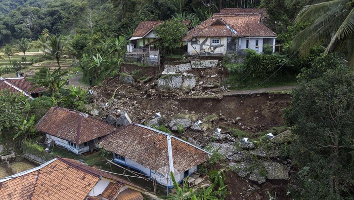 Bencana tanah longsor di Tasikmalaya Warga berjalan melintasi material tanah longsor yang menimbun jalan dan rumah di Desa Banyurasa, Kabupaten Tasikmalaya, Jawa Barat, Kamis (4/5/2023). Curah hujan yang tinggi di Kabupaten Tasikmalaya mengakibatkan jalan penghubung Kecamatan Sukahening dengan Cisayong tertutup material tanah longsor dan menyebabkan dua rumah tertimbun tanah longsor, serta 15 jiwa terpaksa mengungsi. ANTARA FOTO/Adeng Bustomi/rwa.