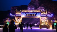 Turis menyaksikan pertunjukan cahaya di bentang alam Danxia, Zhangye, Provinsi Gansu, China, Rabu (3/4/2023).