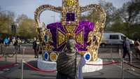 Seorang wanita memotret instalasi seni mahkota raja di pusat kota London, Inggris, Rabu (3/5/2023).  