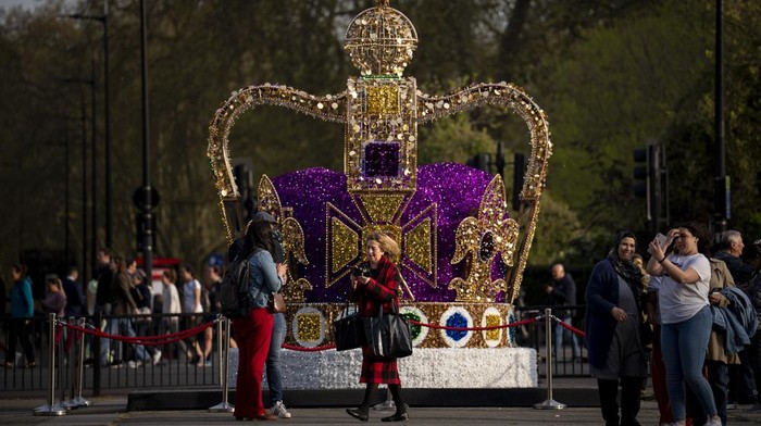 People walk by an art installation depicting the St Edward's crown in central London, Wednesday, May 3, 2023. The Coronation of King Charles III will take place at Westminster Abbey on May 6. (AP Photo/Vadim Ghirda)