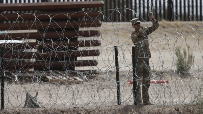 Members of the Texas National Guard install a barbed-wire barrier on the border between El Paso, Texas and Ciudad Juárez, as seen from Ciudad Juárez, Mexico, Wednesday, May 3, 2023. The Biden administration has requested 1,500 troops for the U.S.-Mexico border amid an expected migrant surge following the end of pandemic-era restrictions. (AP Photo/Christian Chavez)