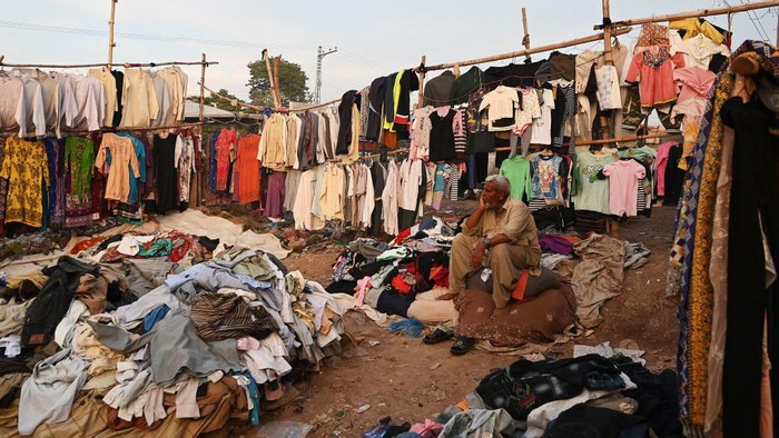 Pakistan Catat Rekor Inflasi Tertinggi di 36,4 Persen A vendor selling second hand clothes waits for customers at a roadside bazaar in Islamabad on May 2, 2023. - Pakistan's year-on-year inflation hit 36.42 percent in April -- its highest ever recorded -- as the government introduced new taxes and raised fuel prices in a bid to meet conditions set by the International Monetary Fund (IMF) to unlock a much-needed bailout. (Photo by Aamir QURESHI / AFP) (Photo by AAMIR QURESHI/AFP via Getty Images)