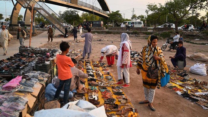 Pakistan Catat Rekor Inflasi Tertinggi di 36,4 Persen People browse through second hand footwear for sale at a roadside bazaar in Islamabad on May 2, 2023. - Pakistan's year-on-year inflation hit 36.42 percent in April -- its highest ever recorded -- as the government introduced new taxes and raised fuel prices in a bid to meet conditions set by the International Monetary Fund (IMF) to unlock a much-needed bailout. (Photo by Aamir QURESHI / AFP) (Photo by AAMIR QURESHI/AFP via Getty Images)