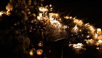 Mereka menaruh bunga dan menyalakan lilin untuk mengenang para korban.