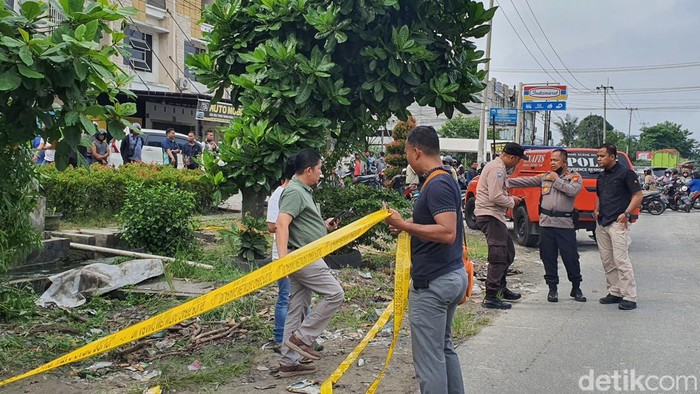 Polisi saat cek TKP mayat yang telah ditutupi spanduk putih (Raja Adil Siregar / detikcom)