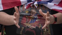 Seorang penggemar keluarga kerajaan memakai baju bergambar Raja Charles III. AP/Vadim Ghirda  