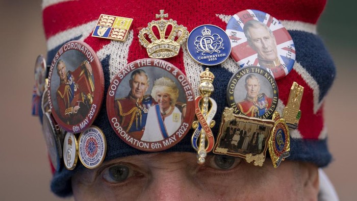 Royal enthusiast John Loughrey wears a hat decorated with royal memorabilia while standing along the Kings Coronation route at The Mall in London, Tuesday, May 2, 2023. The Coronation of King Charles III will take place at Westminster Abbey on May 6. (AP Photo/Vadim Ghirda)