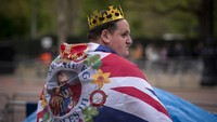 Penggemar kerajaan Patrick ONeil berdiri di sepanjang rute Penobatan Raja di The Mall di London. AP/Vadim Ghirda  