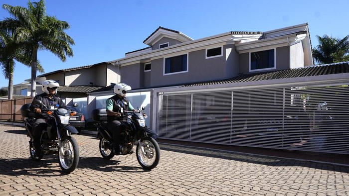 Potret Rumah Mantan Presiden Brasil Jair Bolsonaro Digeledah Polisi Condo security guards pass in front of the home of former Brazilian President Jair Bolsonaro after Federal Police agents carried out a search and seizure warrant in Brasilia, Brazil, Wednesday, May 3, 2023. When asked about the search of Bolsonaroβs home in Brasilia, the Federal Police press office gave a statement saying officers were carrying out searches and arrests related to the introduction of fraudulent data related to the COVID-19 vaccine into the nationβs health system. (AP Photo/Eraldo Peres)