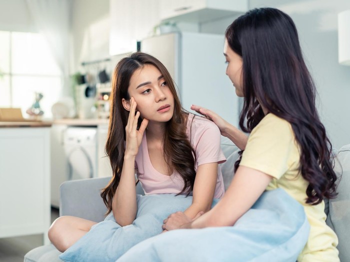 Asian beautiful woman comforts upset girl friend crying for problem. Attractive carring female support, consoling and understand empathy to stressed young sister in tears at home. Family relationship.