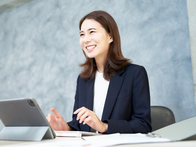 Business woman doing desk work with a smile at office