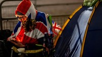 Para penggemar mendirikan kemah dengan menggunakan terpal dan tidak lupa dengan hiasan keluarga kerajaan di sepanjang jalan ikonik di London ini.