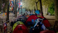 Para pendukung kerajaan berkemah di sepanjang rute yang akan dilewati Raja Charles III di dekat Istana Buckingham, London, Inggris, Kamis (4/5/2023).  