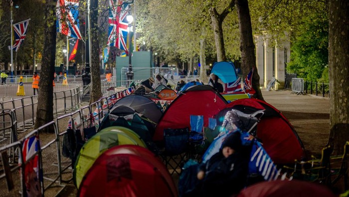 Demi Nonton Penobatan Raja Charles III, Warga London Kemah di Pinggir Jalan LONDON, ENGLAND - MAY 04: Royalists, or supporters of the monarchy, sit together alongside the planned route of King Charles III near Buckingham Palace on May 04, 2023 in London, England. The coronation of the king and Queen Consort Camilla will take place on May 6, part of a three-day celebration. (Photo by Brandon Bell/Getty Images)