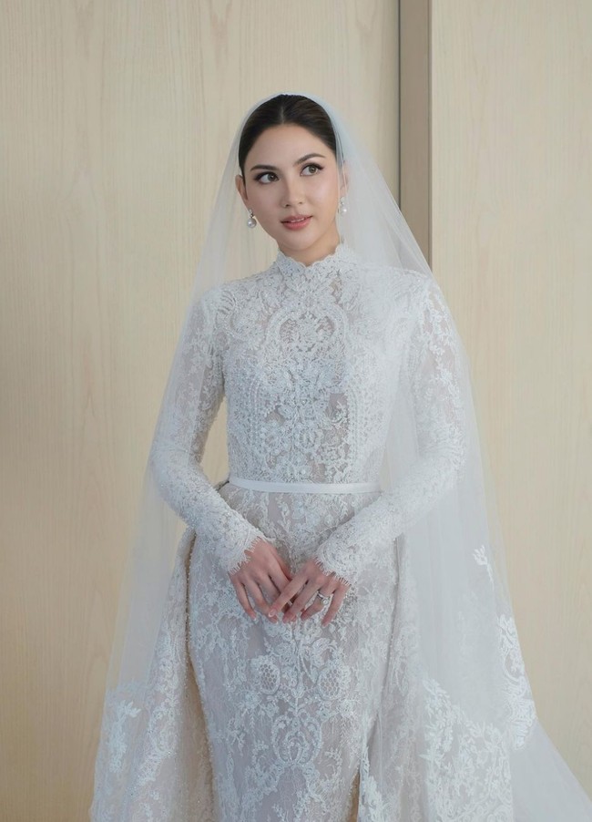 Untuk acara pemberkatan, bintang ‘Marriage with Benefits’ ini mengenakan gaun putih rancangan desainer bridal Yefta Gunawan. Gaun model mermaid dengan kerah tinggi ini sarat akan detail yang merupakan perpaduan lace, bordir serta mutiara. Foto: Instagram/@cherryjks