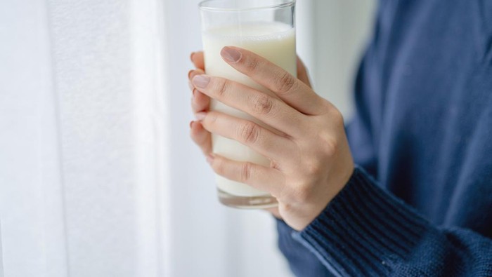 Woman holding a glass of milk.