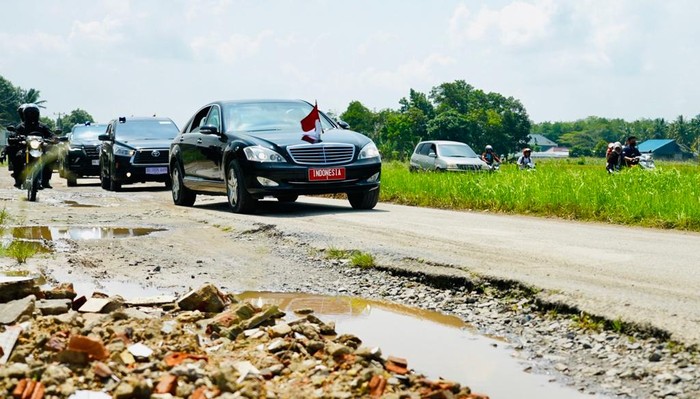 Mobil Indonesia 1 yang ditumpangi Presiden Joko Widodo melintasi Jalan Terusan Ryacudu yang rusak di Marga Agung, Jati Agung, Kabupaten Lampung Selatan, Lampung, Jumat (5/5/2023) pukul 10.30 WIB.