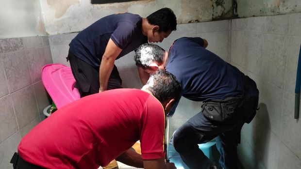 Petugas Damkartan mengevakuasi seekor biawak yang masuk ke saluran air toilet warga di Jalan Untung Surapati, Karangasem, Bali, Jumat (5/5/2023) siang.