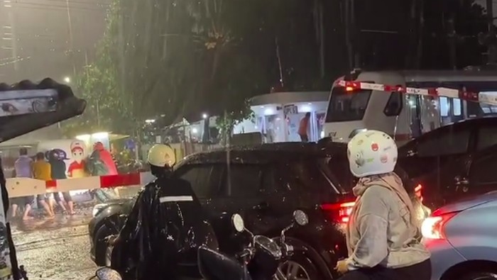 Sebuah mobil tersangkut di rel perlintasan kereta api (KA) di Jakarta Selatan (Jaksel). Saat mobil itu tersangkut, ada kereta bandara dan KRL yang melintas. (dok Pribadi/Billy)