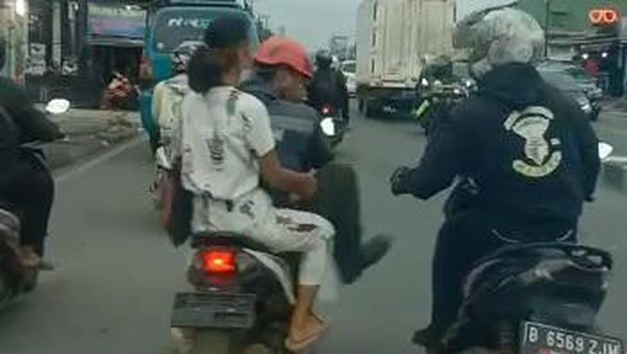 Seorang pengendara motor terlibat cekcok dengan pengawal ambulans di Jalan Raya Parung-Bogor. Pemotor itu sampai menendang pengawal ambulans. (Tangkapan layar video viral)