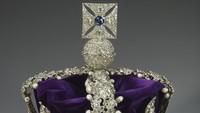 Imperial State Crown. Mahkota ini yang akan ditukar dengan Mahkota St Edward pada akhir Upacara Penobatan. Mahkota ini juga digunakan pada acara-acara seremonial, seperti Pembukaan Parlemen Negara. Istilah Imperial State Crown berasal dari abad kelima belas ketika raja Inggris memilih desain mahkota yang ditutup oleh lengkungan untuk menunjukkan bahwa Inggris tidak tunduk pada kekuatan duniawi lainnya. Mahkota ini dibuat untuk penobatan Raja George VI pada tahun 1937, tetapi didasarkan erat pada mahkota yang dirancang untuk Ratu Victoria pada tahun 1838 oleh perajin perhiasan mahkota saat itu, Rundell, Bridge & Rundell. Foto: (Dokumentasi Kerajaan Inggris - repro via royal.uk)