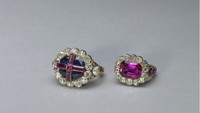 The Sovereigns Ring terdiri dari safir dengan salib rubi bertatahkan berlian. Simbol martabat raja, cincin itu dibuat untuk Penobatan Raja William IV pada tahun 1831, dan semua raja Inggris dari Raja Edward VII dan seterusnya telah menggunakannya pada Penobatan mereka. Cincin Permaisuri (kanan), sebuah batu rubi dalam tatahan emas, dibuat untuk Penobatan Raja William IV dan Ratu Adelaide pada tahun 1831, dan telah digunakan oleh tiga Permaisuri lainnya; Ratu Alexandra, Ratu Mary, dan Ratu Elizabeth Ibu Suri.Foto: (Dokumentasi Kerajaan Inggris - repro via royal.uk)