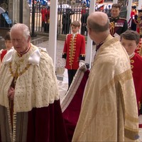 Dalam acara yang dapat secara langsung disaksikan warga dunia, Raja Charles III masuk dengan jubah dengan perpaduan warna putih dan hitam. Dilaporkan bahwa busana tersebut pernah dikenakan kakeknya, Raja George VI, saat acara penobatannya. Charles pun ditemani oleh calon penerusnya, Pangeran George, yang bertugas memegang ekor dari jubahnya.Foto: YouTube The Royal Family