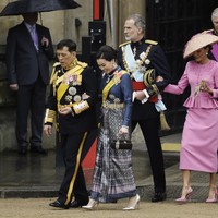 Meski pernikahan mereka sempat dibayangi kabar soal perselingkuhan Raja dengan para selirnya, keduanya tampil mesra dengan bergandengan tangan. (Foto: Jeff J Mitchell/Getty Images)
