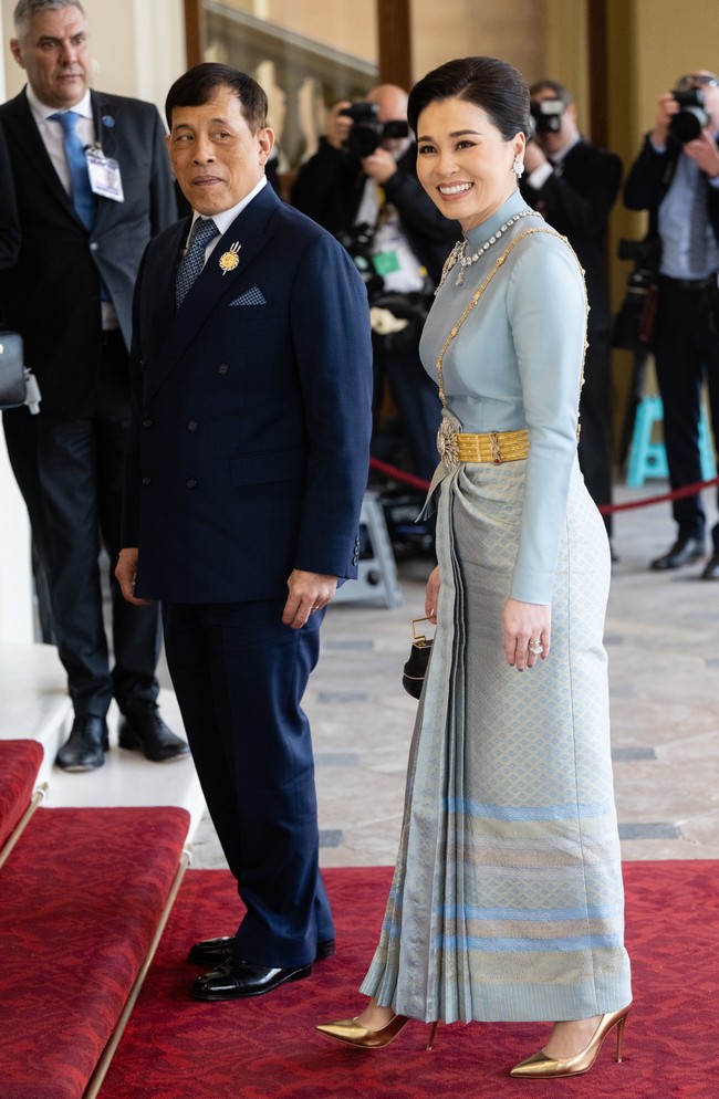 Adapun Ratu Suthida tampil elegan dalam balutan busana tradisional Thailand berwarna powder-blue. Kain tenun sutra dengan aksen emas khas Negeri Gajah Putih jadi andalan sebagai bawahan. (Foto: Samir Hussein/WireImage)