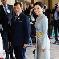 Adapun Ratu Suthida tampil elegan dalam balutan busana tradisional Thailand berwarna powder-blue. Kain tenun sutra dengan aksen emas khas Negeri Gajah Putih jadi andalan sebagai bawahan. (Foto: Samir Hussein/WireImage)