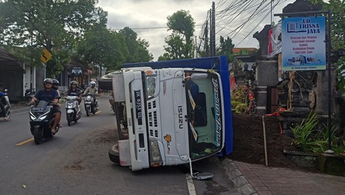 Truk bermuatan pasir terguling di Jalan Raya Untung Surapati, Karangasem, pada Sabtu (6/5/2023). Truk terguling setelah as atau poros roda patah dan terlepas.