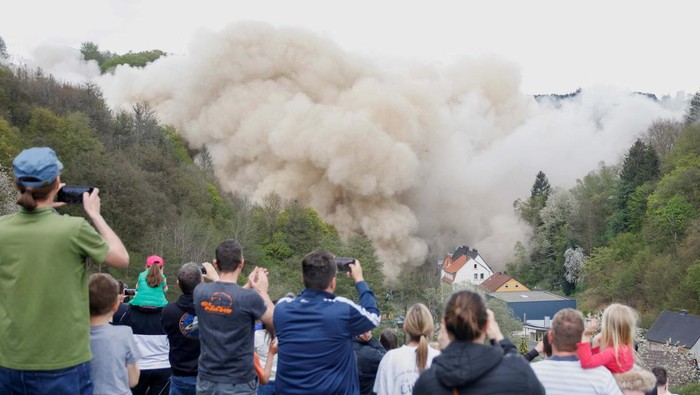 People watch as the dilapidated Rahmedetal bridge on the A45 highway is destroyed in a controlled explosion near Luedenscheid, Germany, May 7, 2023. REUTERS/Leon Kuegeler
