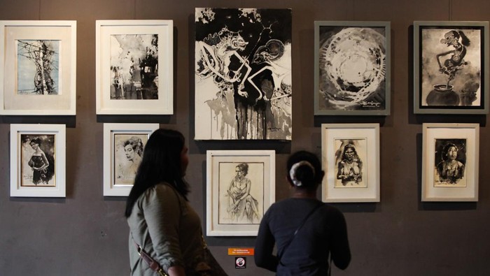 Pengunjung mengamati lukisan pada pameran drawing bertema Goras Gores di Galeri DKS, Surabaya, Jawa Timur, Minggu (7/5/2023). Sebanyak 143 lukisan karya  sepuluh perupa tersebut dipamerkan hingga 14 Mei 2023. ANTARA FOTO/Didik Suhartono/YU