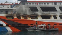 Kapal patroli TNI AL yang mengangkut tim gabungan merapat ke kapal ferry KMP Royce 1 yang terbakar di lepas pantai Pelabuhan Merak untuk menyelidiki dan memastikan penyebab kebakaran, di Merak, Banten, Minggu (7/5/2023).