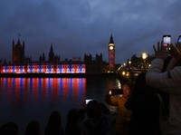 People look on while the Elizabeth Tower which houses Big Ben is seen in the background following Britains King Charles and Queen Camillas coronation ceremony,   in London, Britain May 6, 2023. REUTERS/Marko Djurica