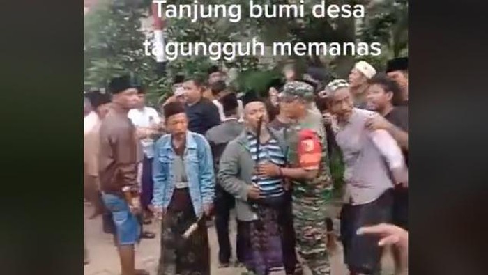 Petugas TNI berupaya menenangkan warga Bangkalan bawa celurit labrak kantor camat saat Pilkades.