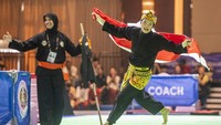 Pesilat putri Indonesia Puspa Arum Sari mengibarkan bendera Merah Putih seusai final nomor seni tunggal putri saat SEA Games 2023 di Chroy Changvar International Convention & Exhibition Center, Phnom Penh, Kamboja, Minggu (7/5/2023).