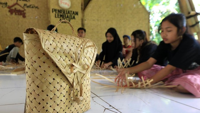 Seorang anak berlatih membuat kerajinan berbahan bambu di Rumah Bambu Sekolah Adat Kampung Batara, Banyuwangi, Jawa Timur, Minggu (7/5/2023). Pelatihan tersebut selain untuk mencetak generasi perajin bambu juga untuk melestarikan tradisi membuat kerajinan lokal yang sekarang sudah tidak lagi banyak digeluti anak muda. ANTARA FOTO/Budi Candra Setya/aww.