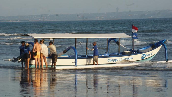 Turis berangkat naik jukung dari Canggu ke perairan Uluwatu atau Pantai Padang-padang, Badung, Minggu (6/5/2023). (Foto: Agus Eka/detikBali)
