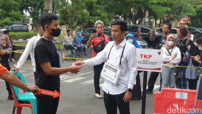 Adegan Niko Setiawan memberikan uang kepada Raja Siregar dalam rekonstruksi kasus penganiayaan Ken Admiral di Mapolda Sumut.