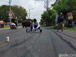 Aksi Teatrikal Pria Seorang Diri Protes Jalan Rusak di Wiyung Surabaya