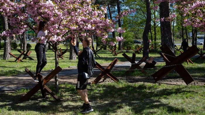 Bunga Sakura Bermekaran di Tengah Gempuran Perang Ukraina KYIV, UKRAINE - MAY 06: People walk in a park near cherry blossom trees and trenches dug to defend the city, as the Russia and Ukraine war continues in Kyiv, Ukraine on May 06, 2023. (Photo by Oleksii Chumachenko/Anadolu Agency via Getty Images)