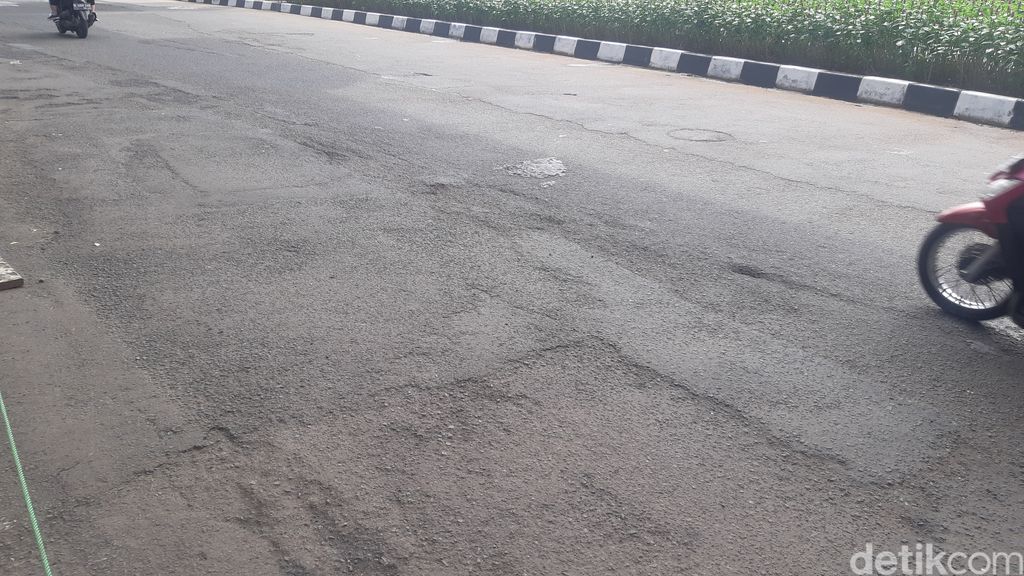 Jalan berlubang di depan kantor Kejagung RI, Jakarta, 8 Mei 2023, pagi. (Danu Damarjati/detikcom)