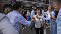 Orang-orang bersulang saat mengikuti perayaan Big Lunch di London. Keagungan abad pertengahan dari upacara penobatan bermula di Inggris pada tahun 1066, tetapi pesta Makan Siang Besar berupaya mendekatkan komunitas beragam Inggris abad ke-21. AP/Emilio Morenatti