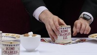 Seorang pelayan memberikan sentuhan akhir pada pengaturan tempat untuk pesta Makan Siang Besar Perdana Menteri Rishi Sunak di Downing Street. Makan Siang Besar adalah upaya untuk tetap menghidupkan semangat bertetangga itu. AP/Frank Augstein