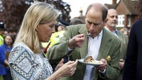 Pangeran Inggris Edward, Duke of Edinburgh dan Sophie, Duchess of Edinburgh mencicipi pai ayam penobatan saat mereka menghadiri Makan Siang Besar bersama penduduk dan perwakilan dari Royal British Legion, the Scouts and the Guides, di desa Cranleigh, Inggris. AP/Peter Nicholls  
