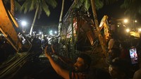 Lusinan orang mencari korban selamat di dalam dan sekitar kapal yang tertimpa bencana pada malam hari, yang sebagian tenggelam. Beberapa menggunakan tali untuk menstabilkan kapal sementara yang lain berada di dalam air, melihat ke dalam jendela kapal.  