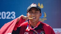 Rashif Amila Yaqin menggigit medali emas yang diraihnya pada nomor aquatlon putra SEA Games 2023.