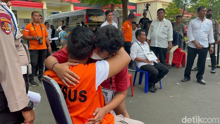 Momen AKBP Achiruddin berpelukan dengan anaknya, Aditya Hasibuan.